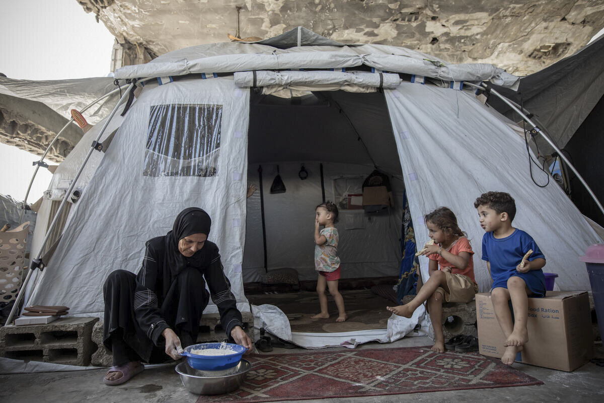A displaced woman in Gaza with a bag of flour received through World Food Programme assistance